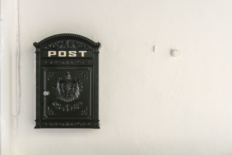 Black metal mailbox on white wall