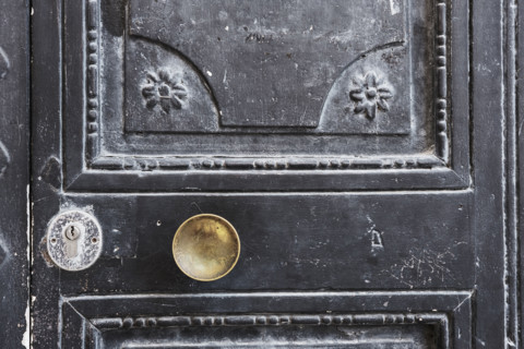 Old black wood door with gold-colored door knob