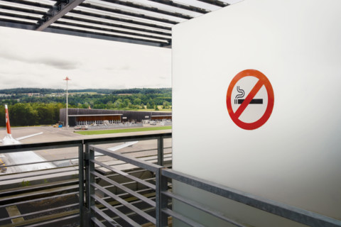 No smoking sign on white wall at airport, Zurich, Switzerland