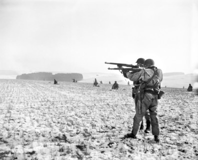 U.S. Infantrymen, attached to the 4th Armored Division, fire at German troops, in the American