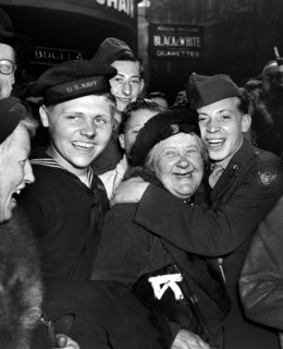 Jubilant American soldier hugging motherly English woman and victory smiles light the faces of