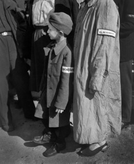 Six-year-old war orphan with Buchenwald badge on his sleeve waiting for his name to be called at