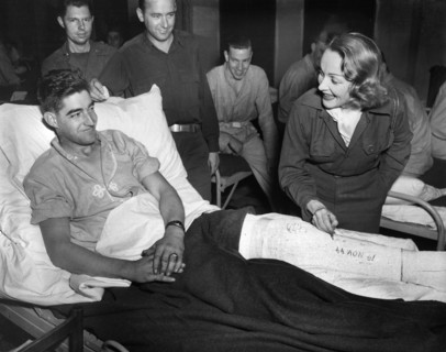 Marlene Dietrich, motion picture actress, autographing cast of Tec 4 Earl E. McFarland of Cavider,