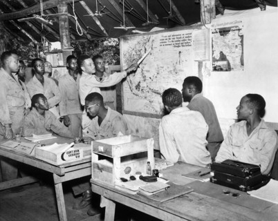 Members of U.S. 477th Anti-aircraft Artillery, Air Warning Battalion, studying maps in operations