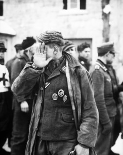 German prisoner shielding his face after being captured by U.S. 16th Infantry Regiment, near