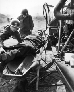 Wounded American being lifted onto helicopter at 21st Infantry Regiment collecting station at