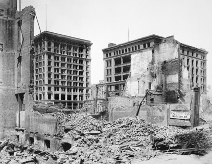 Damaged buildings after earthquake, large building standing is possibly Wells Fargo Express