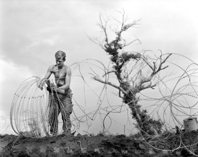 Member of 1st Brigade, 5th Infantry Division (Mechanized), taking down barbed tape (modified form
