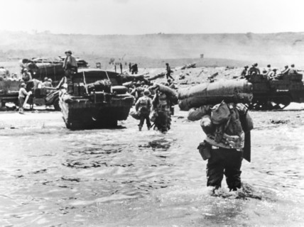 American assault troops with full amphibious military equipment moving onto Omaha Beach,