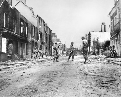 U.S. infantrymen moving through street ruins, Percy, France, U.S. Army Signal Corps, August 2, 1944