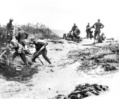 U.S. mortar crew standing back just before firing into Nazi position along Normandy Coast, France,