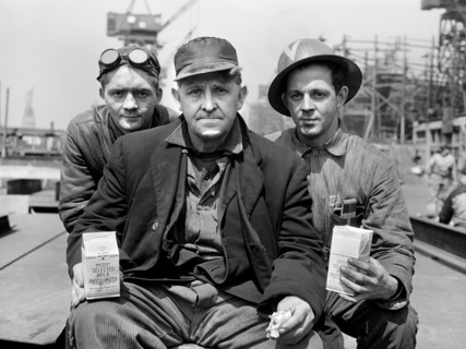 Three factory workers on lunch break, Bethlehem-Fairfield shipyards, Baltimore, Maryland, USA,