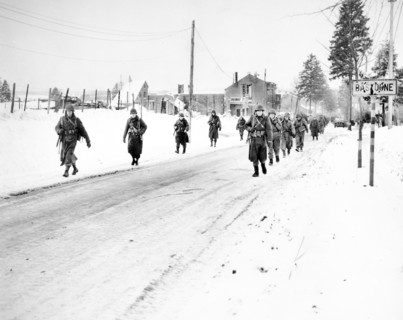 Members of U.S. 101st Airborne Division on the move out of  Bastogne, Belgium, to drive Germans who