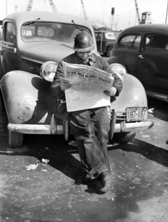Factory worker reading newspaper while on break, Bethlehem-Fairfield shipyards, Baltimore,