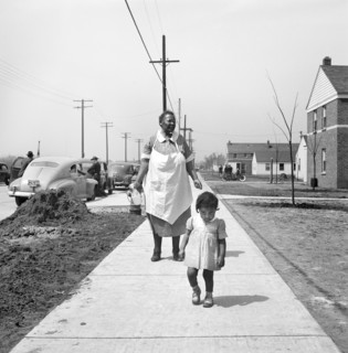 Mother and child waking on sidewalk, Sojourner Truth Homes, a U.S. Federal Housing Project,