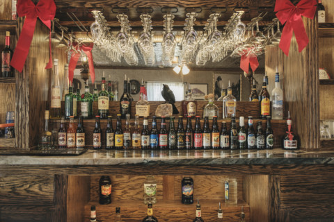 Saloon interior with rows of liquor and beer bottles on bar counter
