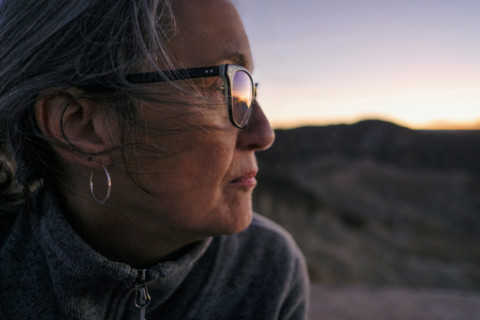 Head shoulders profile of senior adult woman looking at sunset, Zabriskie Point, Death Valley,