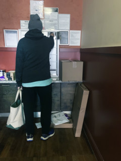 Rear view of man checking mailbox in apartment building lobby, Brooklyn, New York, USA