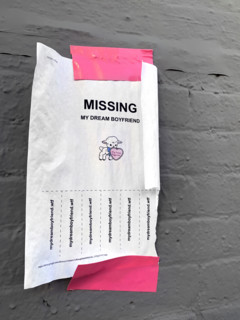 Sign posted for missing dream boyfriend on brick wall secured with pink adhesive tape, Brooklyn,