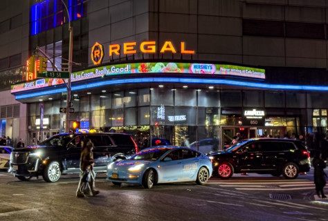 Regal movie theaters and street scene at night, New York City, New York, USA
