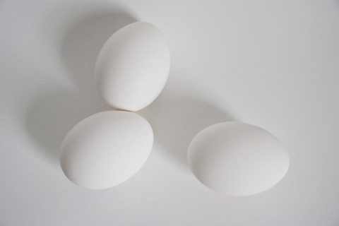 High angle view of three white eggs