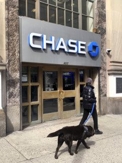 Chase Bank retail branch, building exterior and sidewalk scene with woman walking a dog, New York