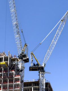 Construction cranes atop new residential building under construction, New York City, New York, USA