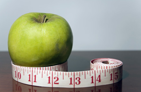 Green apple with tape measure