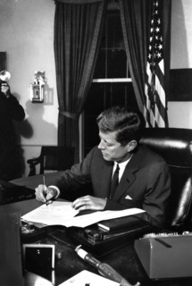 U.S. President John F. Kennedy signing the Interdiction of the Delivery of Offensive Weapons to