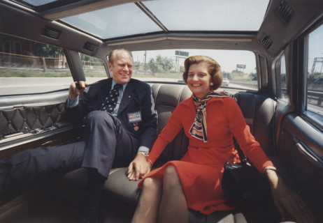 U.S. President Gerald Ford and U.S. First Lady Betty Ford holding hands while riding in the