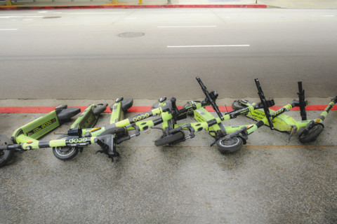 Row of fallen electric rental scooters on sidewalk, Los Angeles