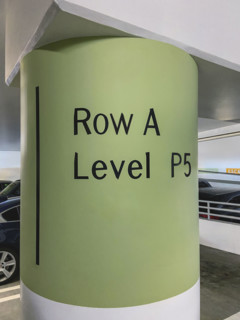 Painted cement column in public parking garage informing customers of their parking location