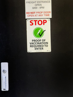 Proof of vaccination sign on freight entrance door, New York City