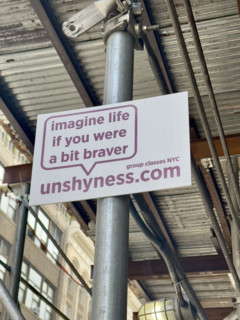 Advertising placard attached to building scaffold, New York City