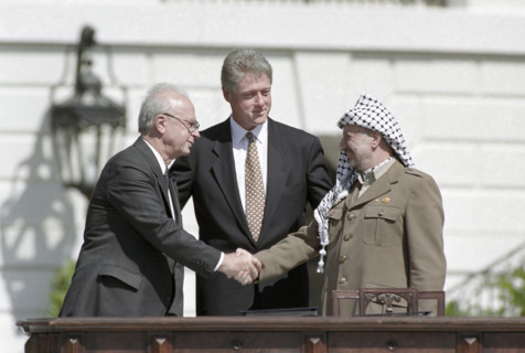 U.S. President Bill Clinton watching handshake between Israeli Prime Minister Yitzhak Rabin and