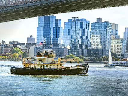 Tugboat in East River with Williamsburg cityscape in background, Brooklyn, New York City, New York,