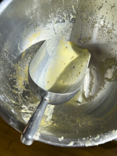 High angle view of metal bowl and scoop used to mix cornbread
