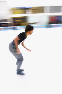 Young adult man ice skating at outdoor ice rink, blurred motion, Bryant Park, Manhattan, New York