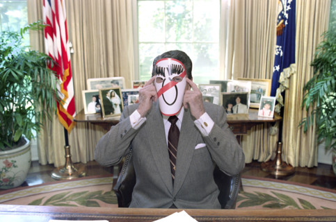 U.S. President Ronald Reagan wearing an anti-Michael Dukakis mask in the White House Oval Office,