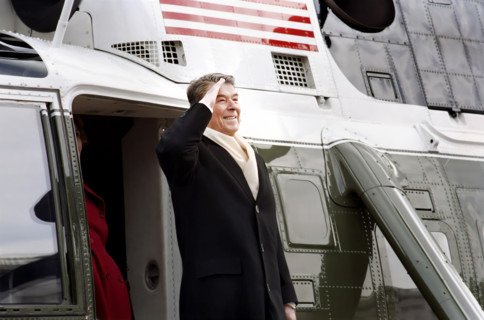 Former U.S. President Ronald Reagan saluting as he departs aboard helicopter as he leaves U.S.