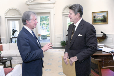 U.S. President Ronald Reagan with former U.S. President Jimmy Carter in the White House Oval