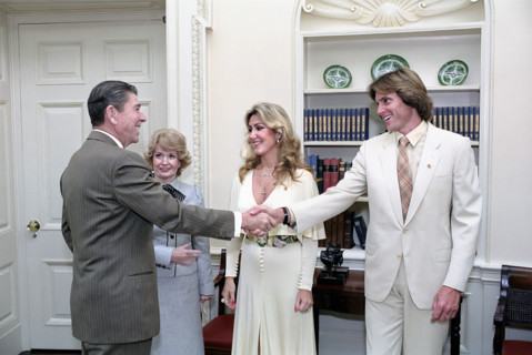 U.S. President Ronald Reagan shaking hands with Bruce Jenner, with his wife Linda Jenner and