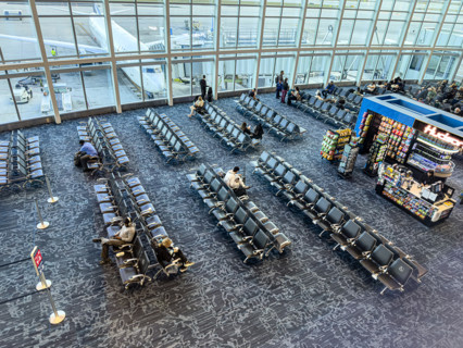 High angle view of travelers relaxing in departure lounge, Delta Airlines, Fort