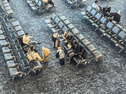 High angle view of travelers relaxing in departure lounge, Delta Airlines, Fort