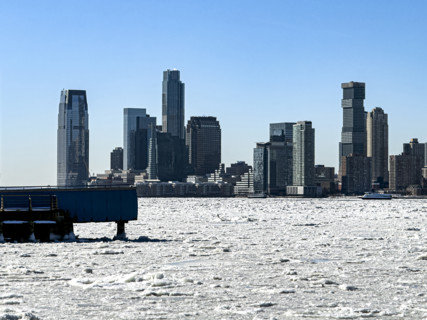 View of Jersey City, New Jersey, USA skyline across frozen Hudson River