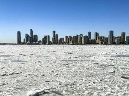 View of Jersey City, New Jersey, USA skyline across frozen Hudson River