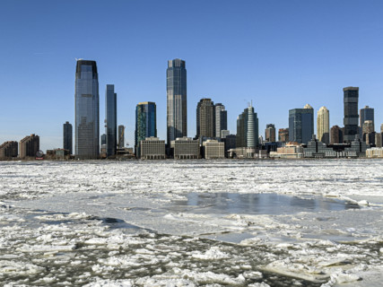 View of Jersey City, New Jersey, USA skyline across frozen Hudson River