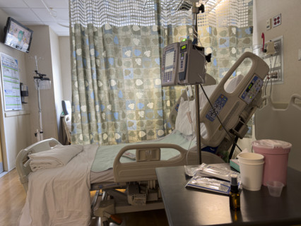 Empty hospital bed in patient room with medical equipment