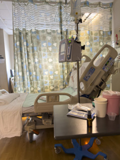 Empty hospital bed in patient room with medical equipment
