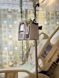Empty hospital bed in patient room with medical equipment